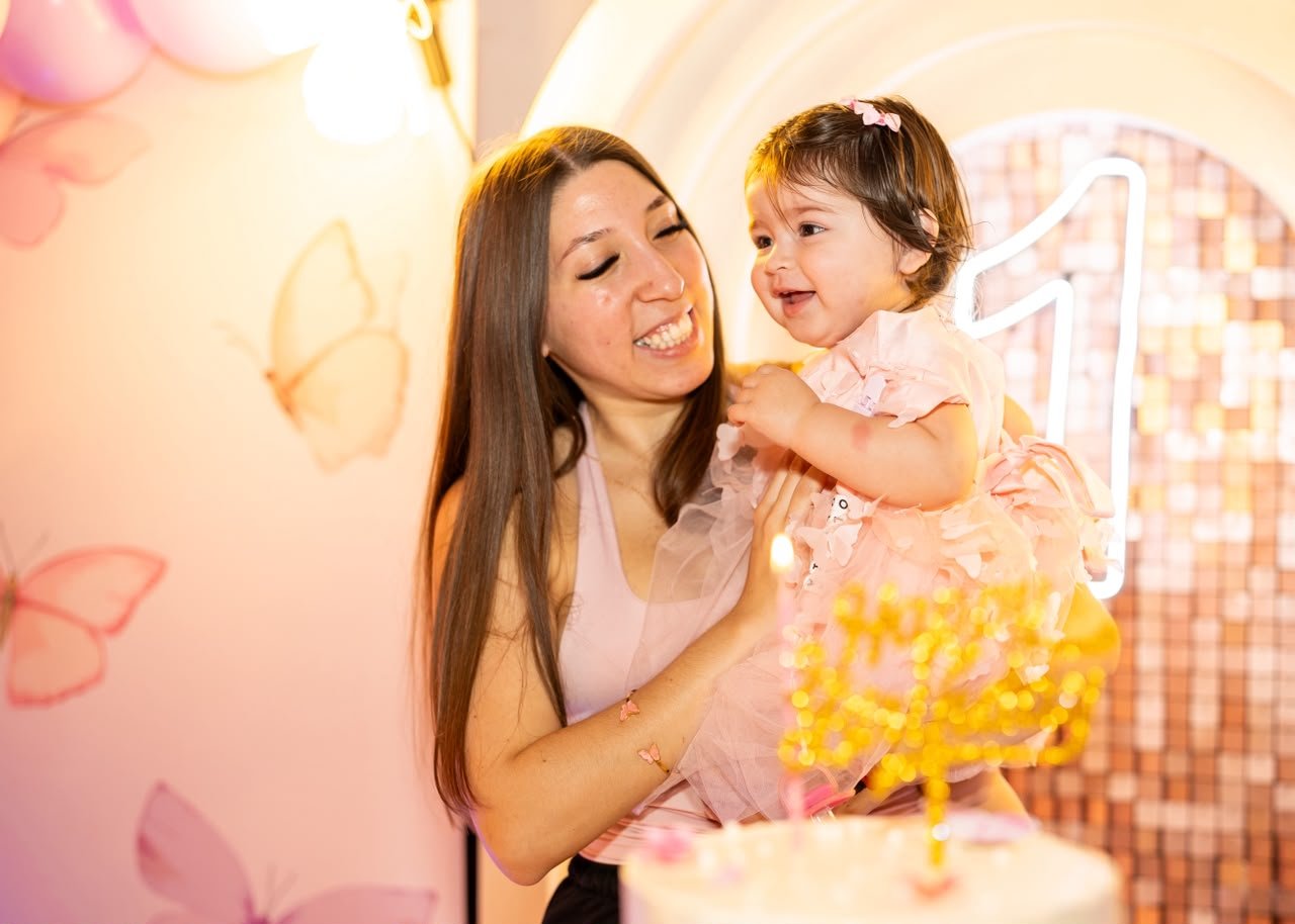 Mamá con su beba frente a la torta del primer añito