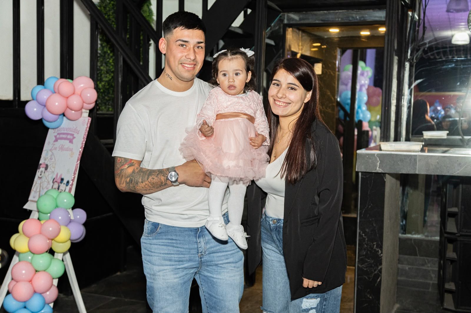 Familia en la entrada del salón junto al arco de globos